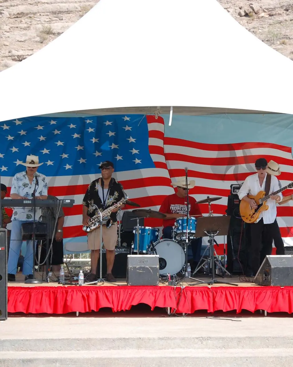Live band performance under outdoor tent with American flag backdrop in Las Vegas