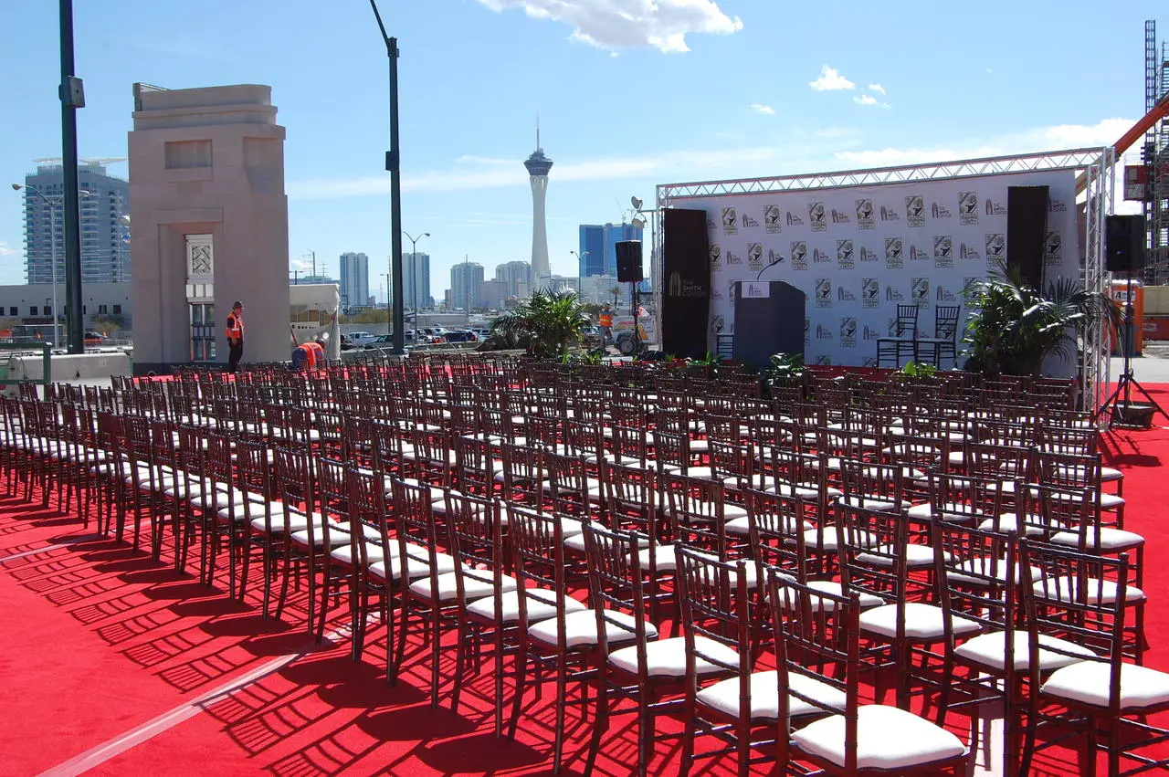 Outdoor groundbreaking ceremony with red carpet seating and stage against Las Vegas skyline