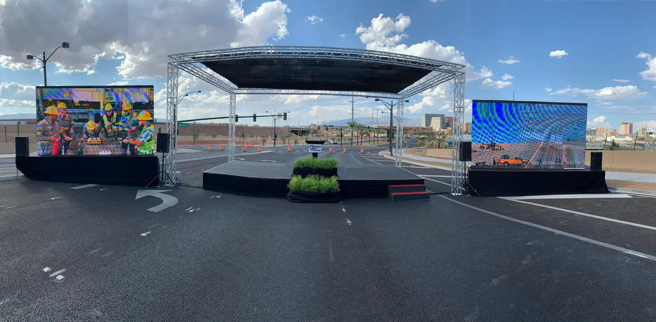 Outdoor groundbreaking ceremony stage with LED screens and construction theme in Las Vegas
